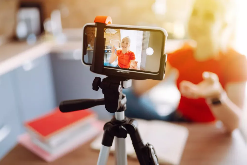 Jeune auto entrepreuneuse se filmant avec son smartphone sur trepied Jeune auto entrepreuneuse se filmant avec son smartphone sur trépied : réalisation d'un film sur les 8 Conseils pour Filmer des Vidéos de Qualité avec Son Smartphone